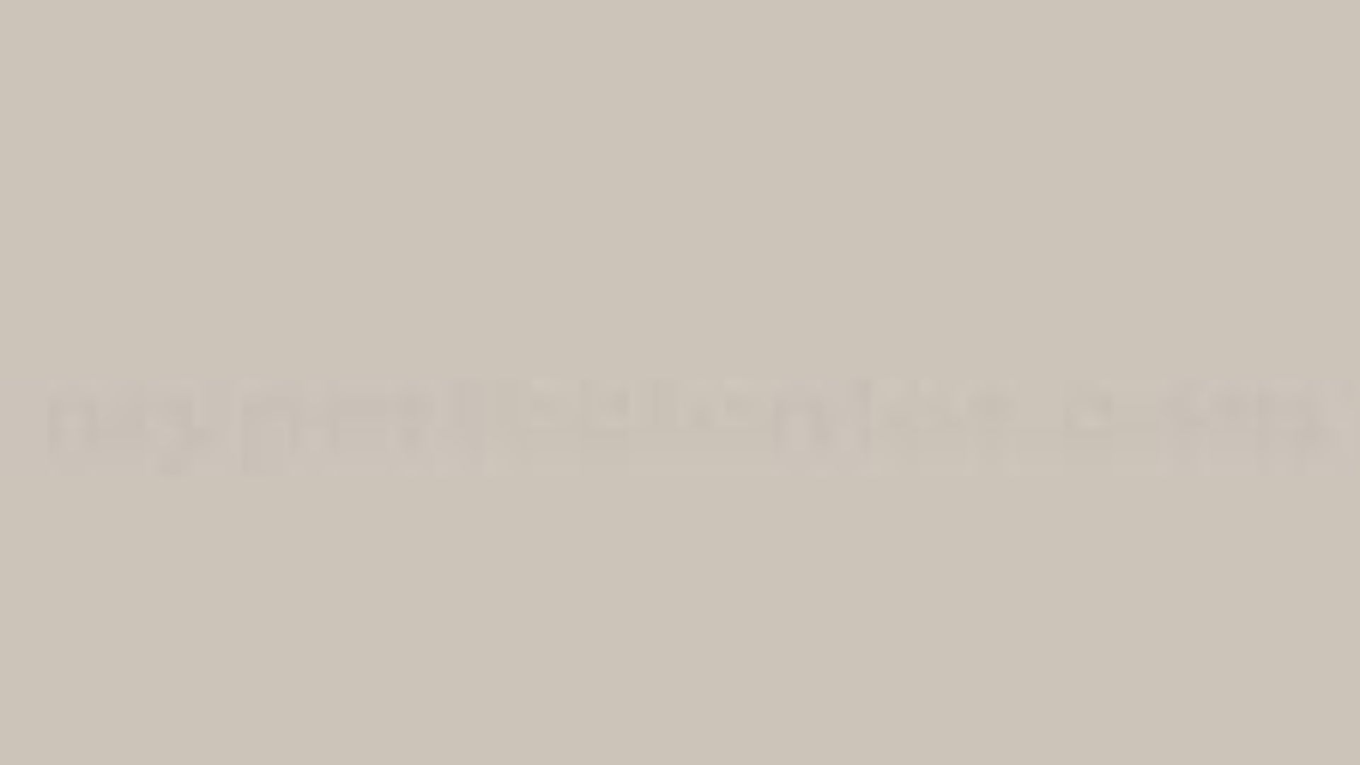 A blurry gray and beige gradient, creating an abstract, soothing background with no distinct shapes or elements, evoking a calm, neutral tone.